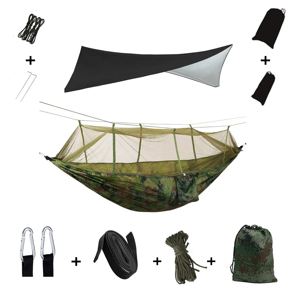 Camping Hängematte in Grüntönen, mit aufgezogenem Moskitonetz & Regendach im Wald.