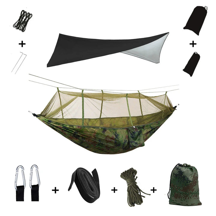 Camping Hängematte in Grüntönen, mit aufgezogenem Moskitonetz & Regendach im Wald.