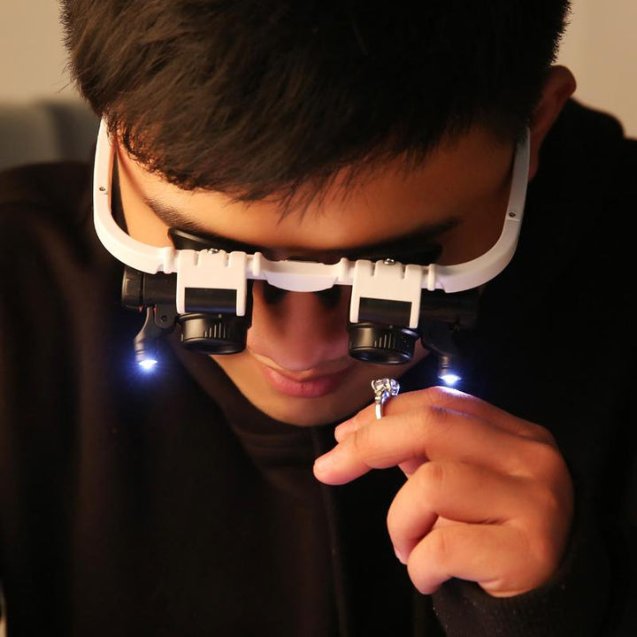 Mann nutzt LED-Brillenlupe für präzise Elektronik-Reparaturen mit freier Hand.
