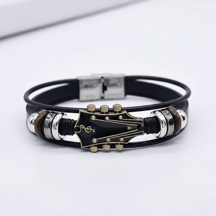 Unisex Lederarmband mit verstellbarem Verschluss und Gitarren-Motiv, präsentiert auf neutralem Hintergrund.