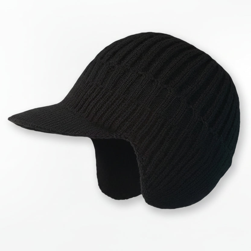 Gemütliche Nordic-Wintermütze auf einem schneebedeckten Baumstamm, bereit für den Winter.