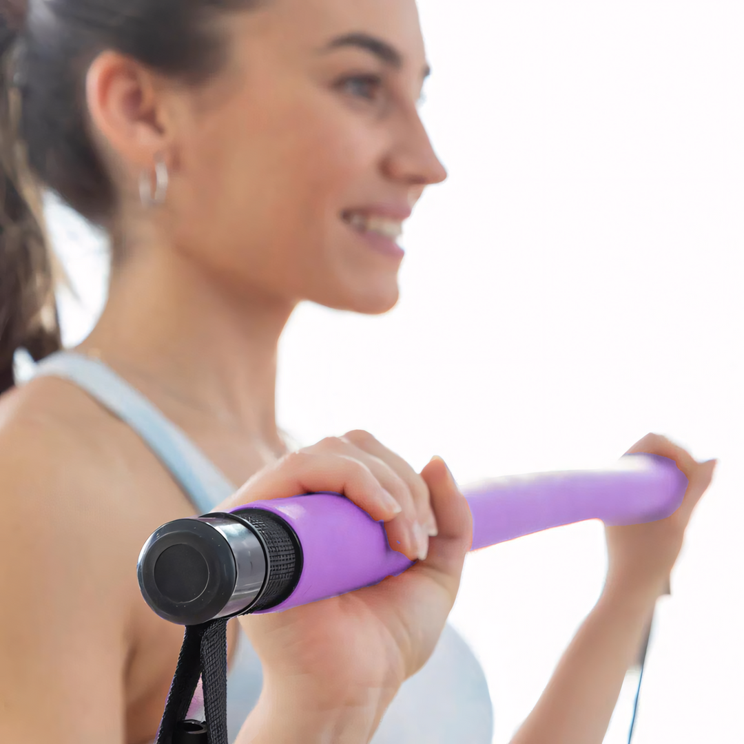 Mann nutzt Pilates-Stange mit Widerstandsband für effektives Oberkörper-Workout zu Hause. Unisex Fitnessgerät.