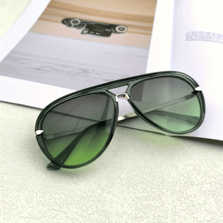 Pilotenbrille auf sommerlichem Hintergrund, symbolisiert Freiheit und zeitlosen Stil. Mit UV-Schutz.