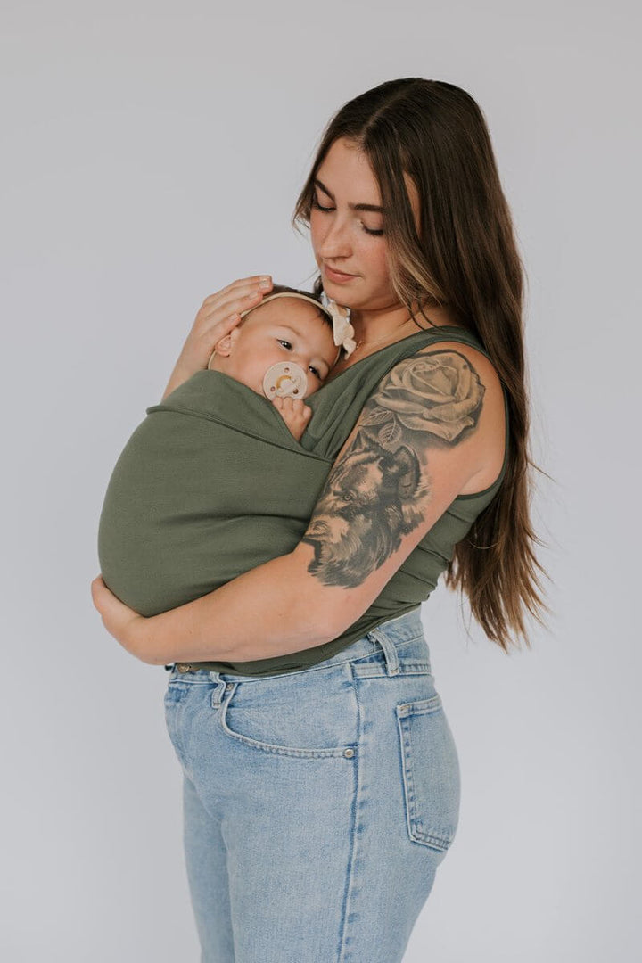 Elternteil spaziert entspannt mit Baby im komfortablen Tragetuch T-Shirt; ideale Babytrage für unterwegs.