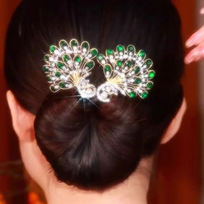 Detailaufnahme der Vintage Pfauen Haarspange; kunstvolle Details in leuchtenden Blau-, Grün- und Rottönen.