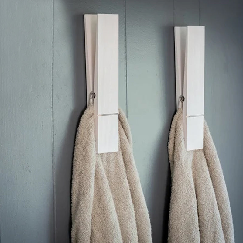 Wandmontierter Handtuchhalter aus Holz mit originellem Wäscheklammer-Detail.