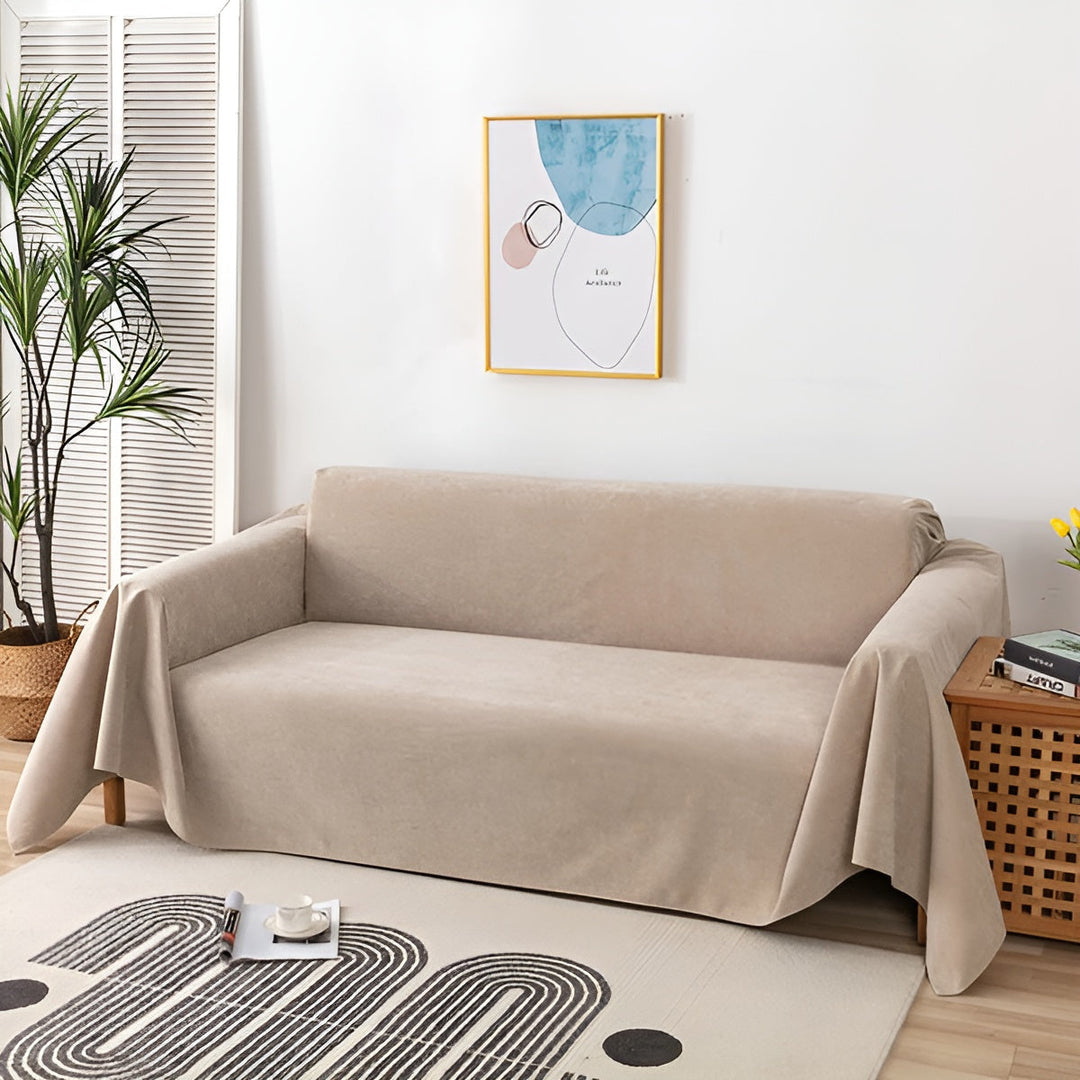 Wasserdichte Sofadecke auf einer Couch im Wohnzimmer. Bietet stilvollen Schutz vor Flecken & Tierhaaren.