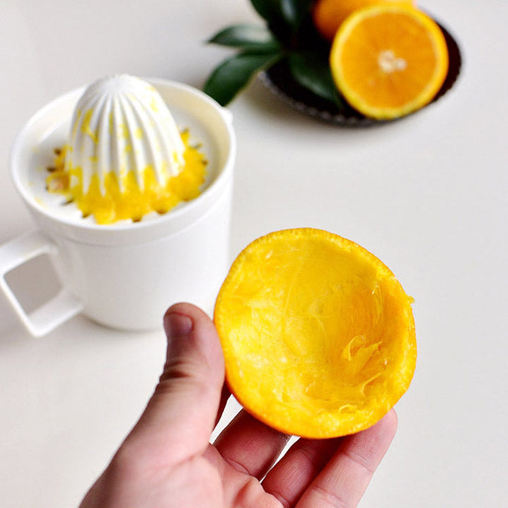Stilvolle manuelle Keramik-Saftpresse, perfekt für frischen Saft am Frühstückstisch.