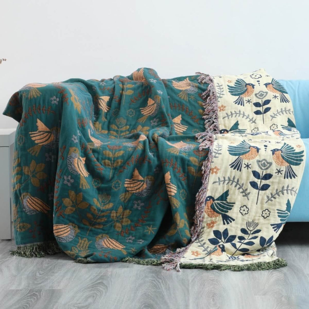 Gemütliche skandinavische Wohndecke mit Vogelmotiv, wendbar und dekorativ. Eine weiche Baumwoll-Kuscheldecke fürs Sofa.