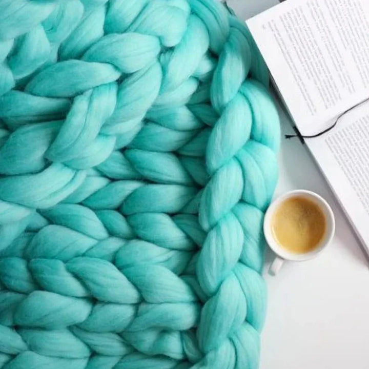 Wintertraum XL Chunky Wolle mit Stricknadeln, bereit für kreative Handarbeit. Perfekt für warme Winterdecken.